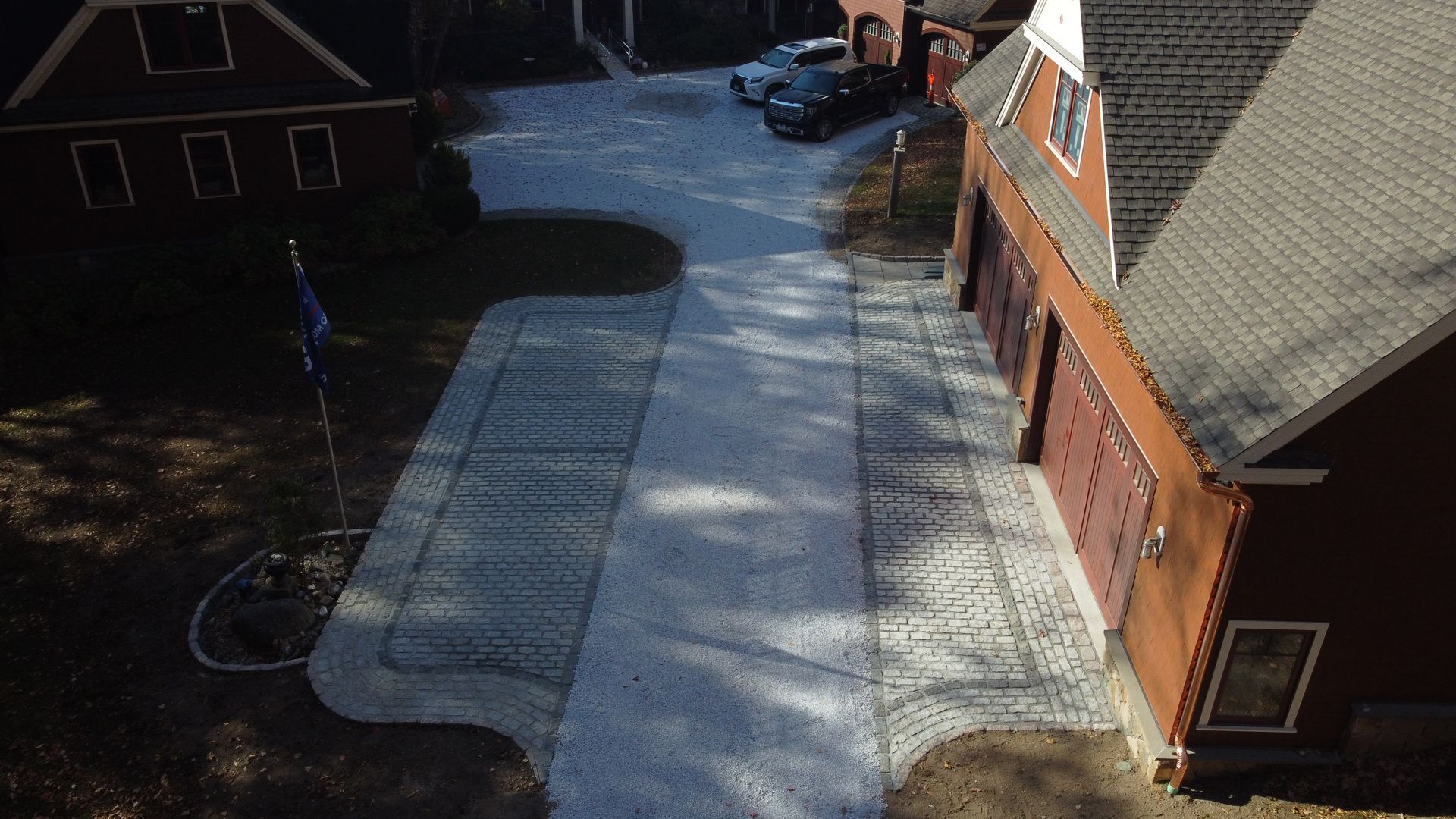 Overhead view of a brick building with a long covered walkway and a snowy driveway in front