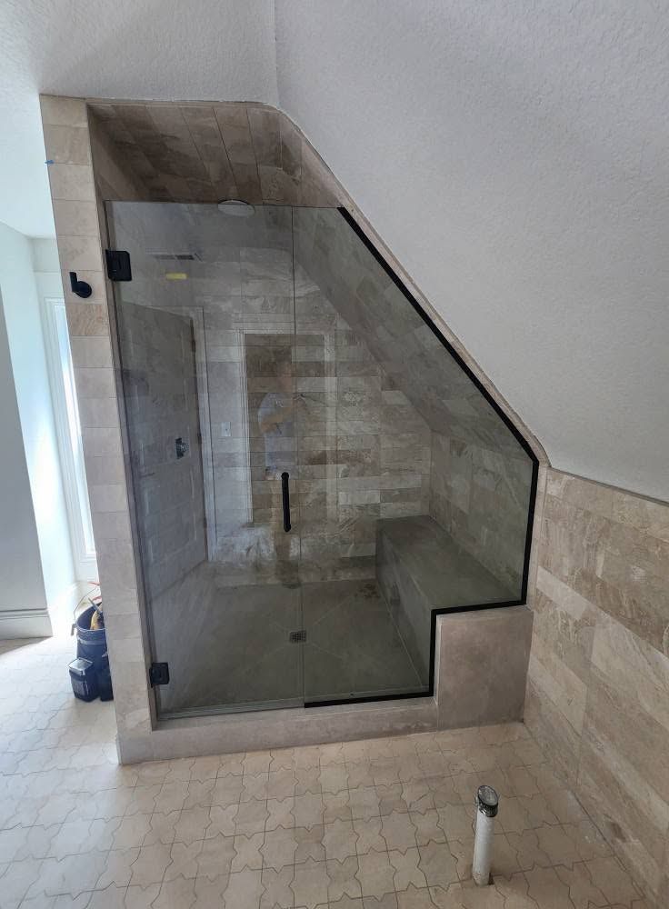 Modern bathroom shower with marble-look tiled walls, sliding glass door, and a recessed niche.