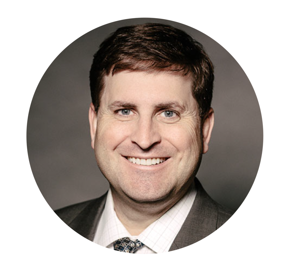 Fiduciary Derek Lewis in a tie is smiling.