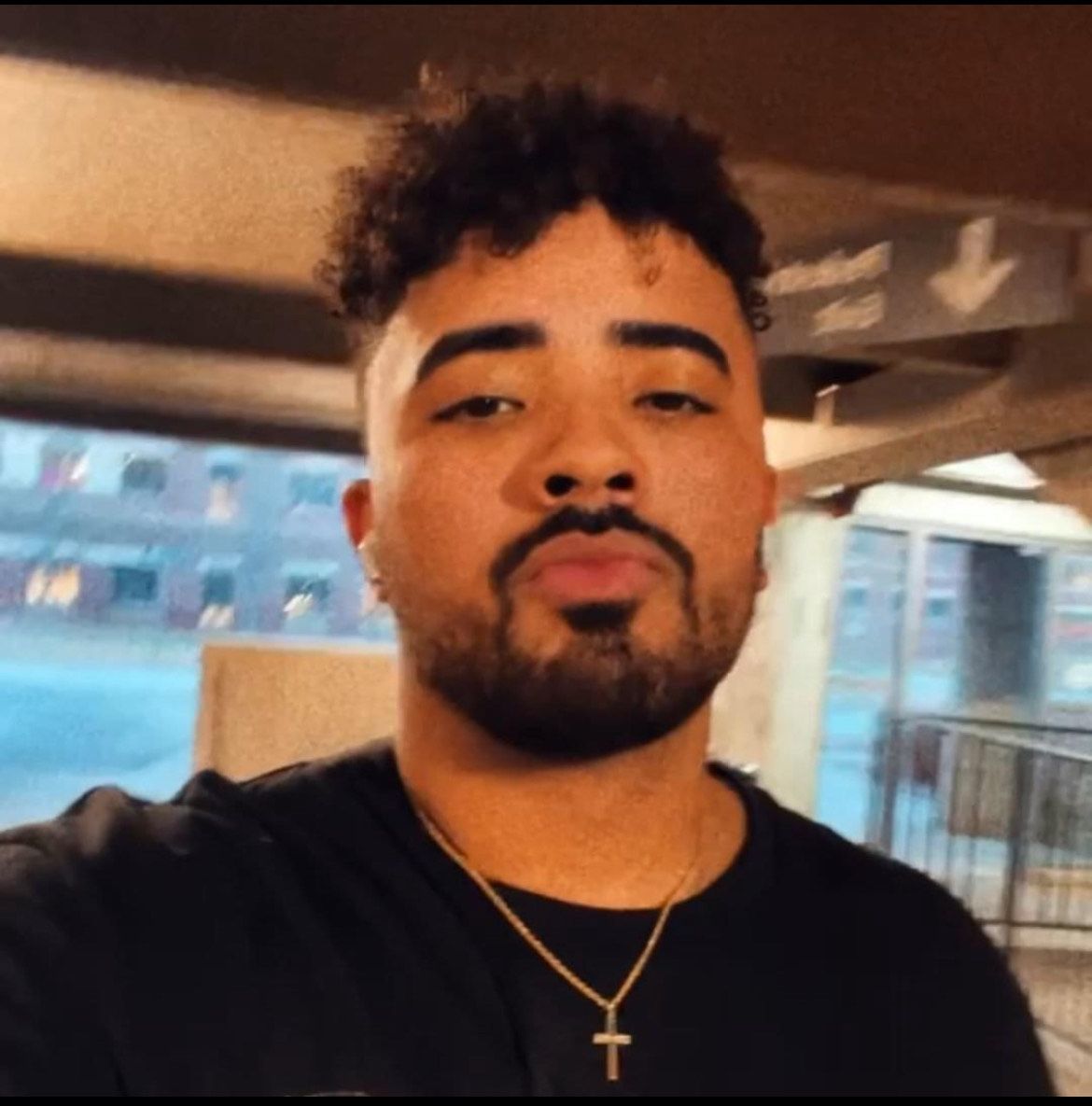 A man with a beard is wearing a cross necklace