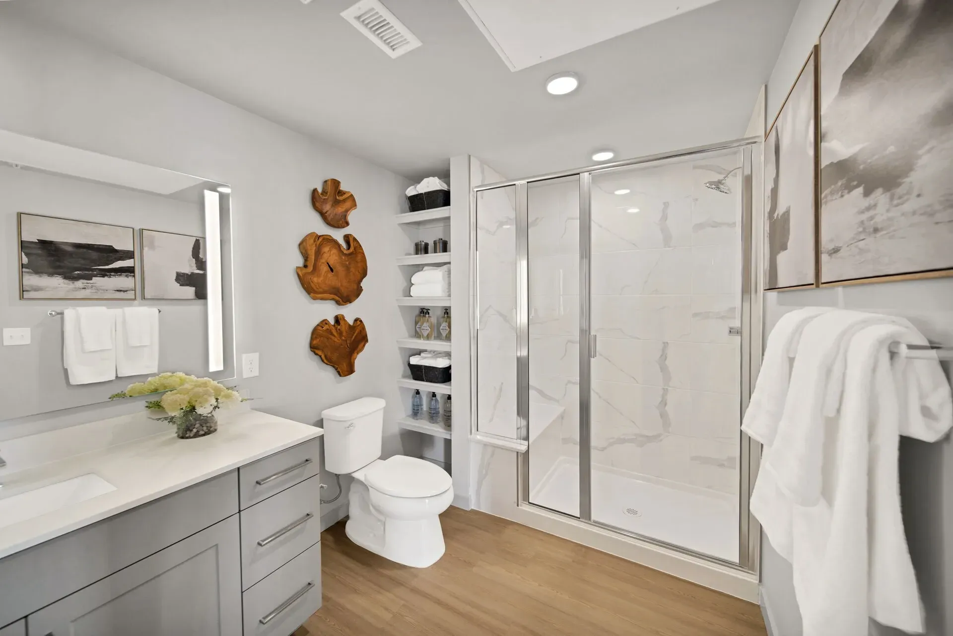Modern bathroom with a vanity, toilet, and glass-enclosed shower.