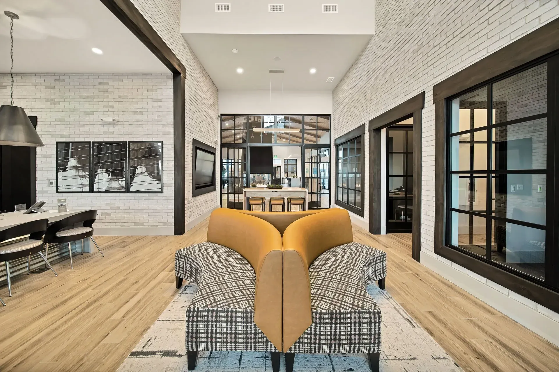 Modern lobby with unique seating, exposed beams, and white brick walls.