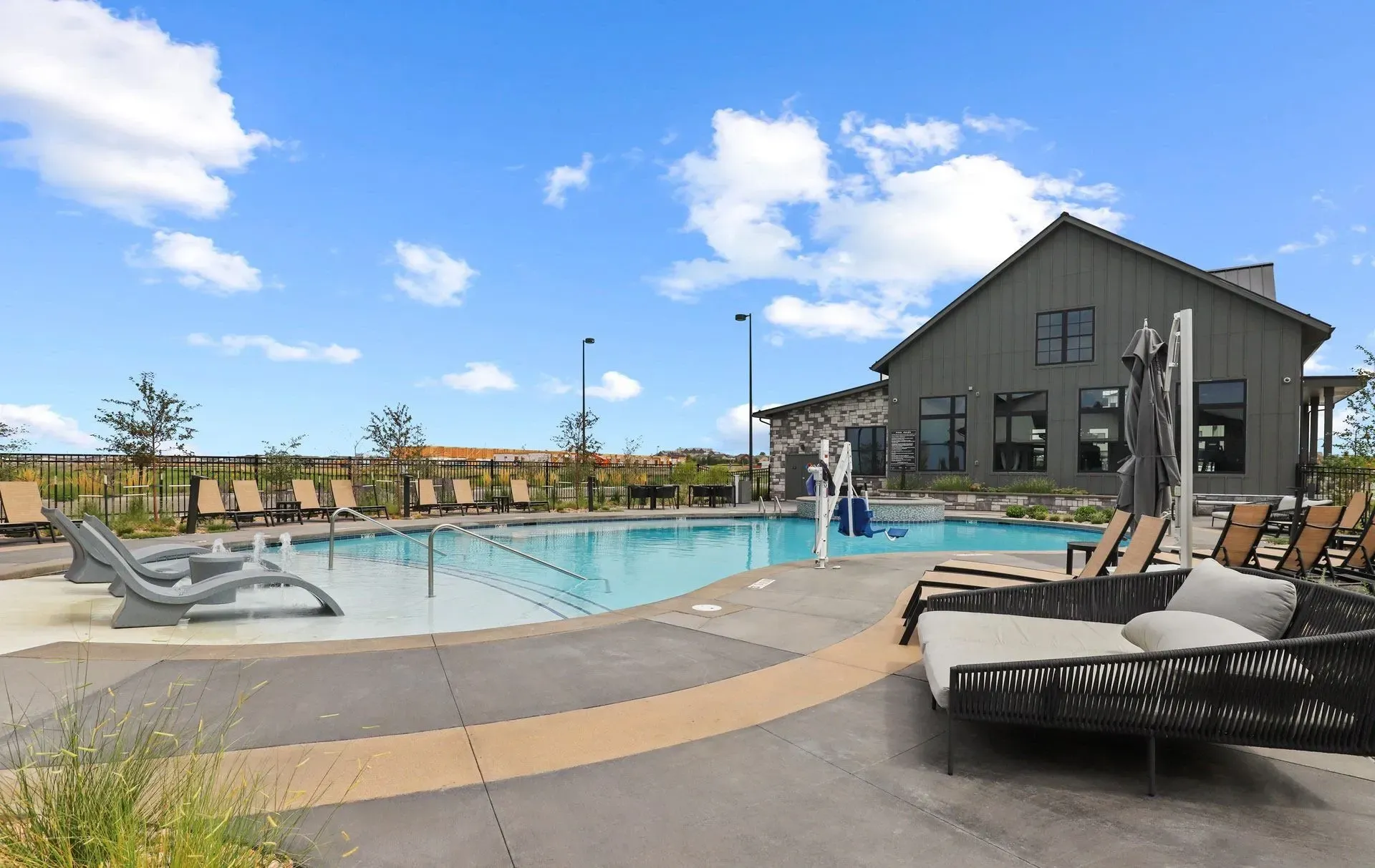 Outdoor swimming pool with lounge chairs and a building in the background