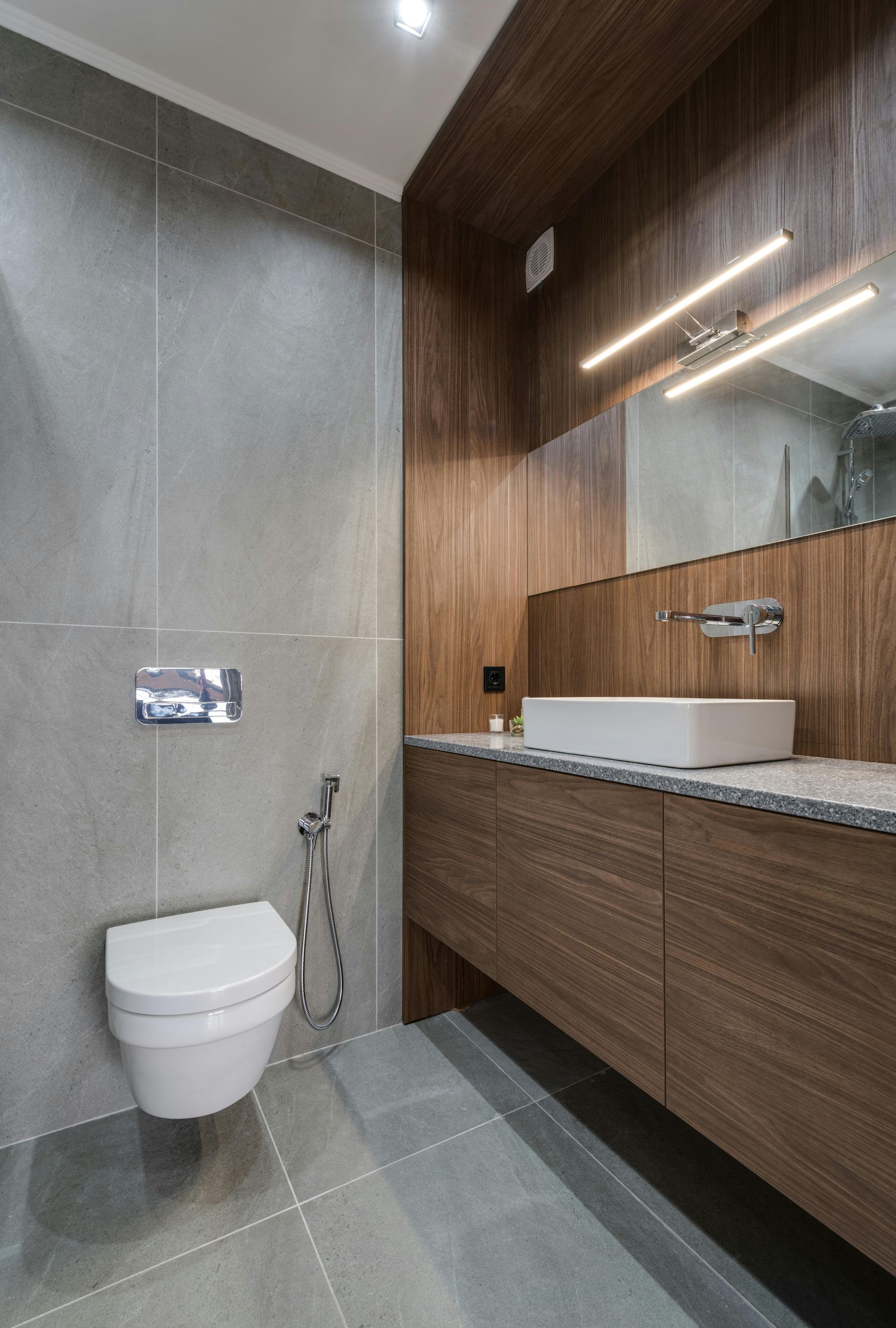 A bathroom with a toilet , sink and mirror.