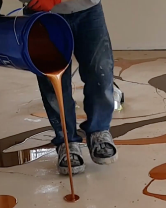 Contractor applying epoxy primer to a prepared concrete floor before coating installation in Madison, Alabama.
