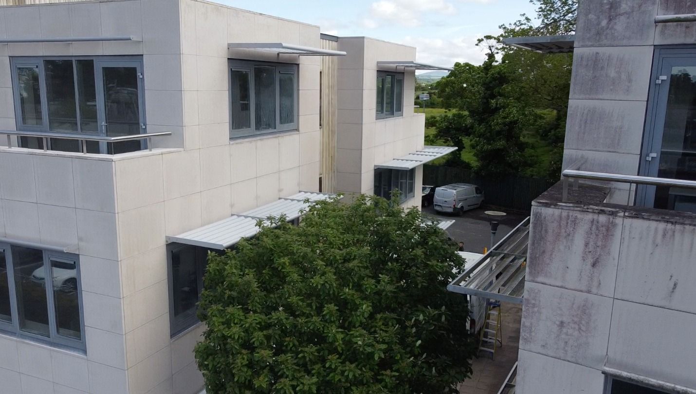 An aerial view of a building with a tree in front of it.