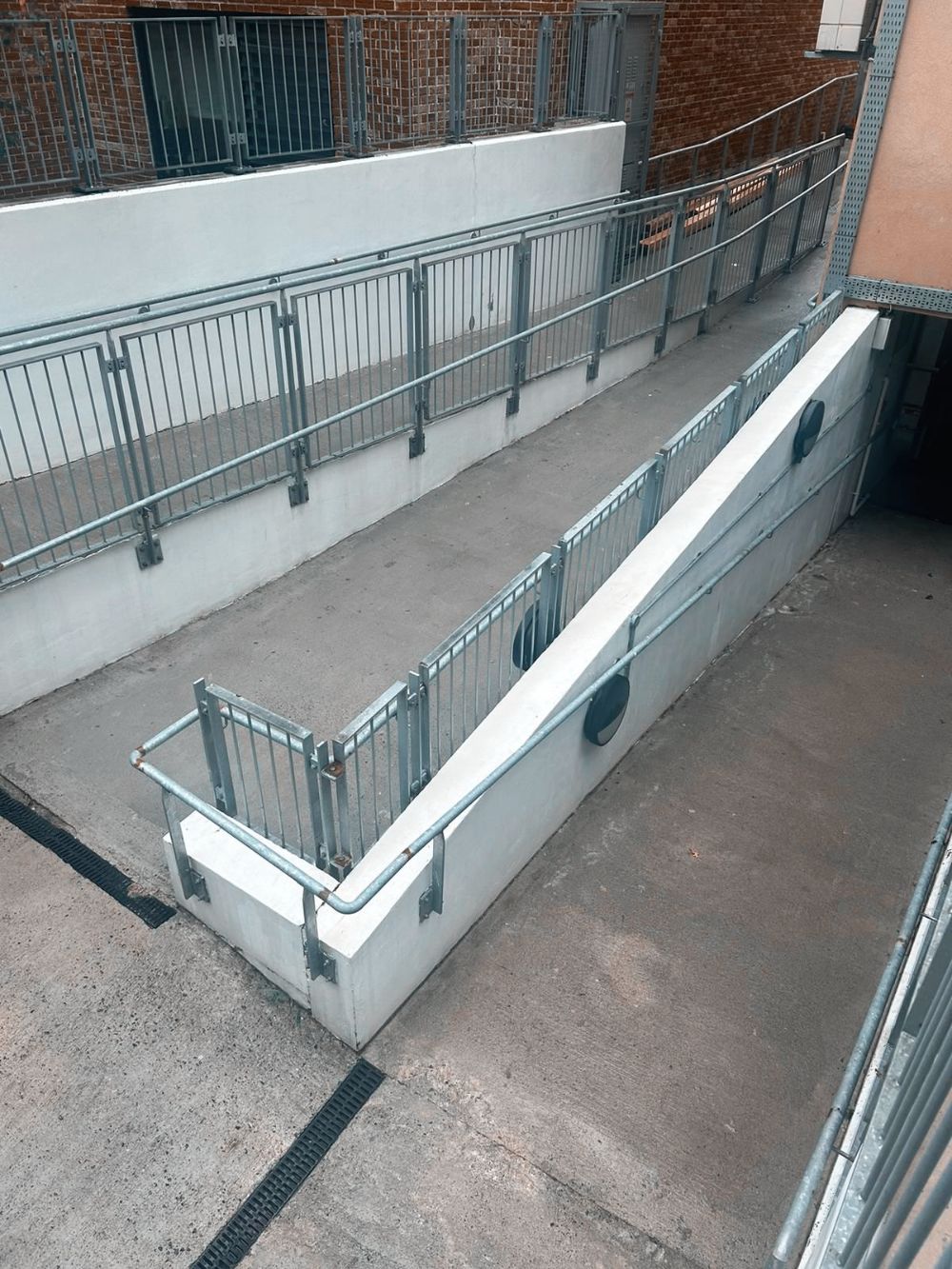 A ramp leading to a building with a railing and stairs.
