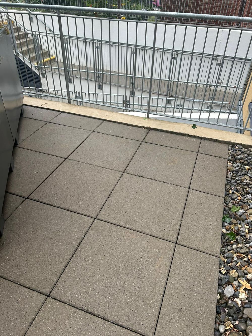 A balcony with a metal railing and tiled floor
