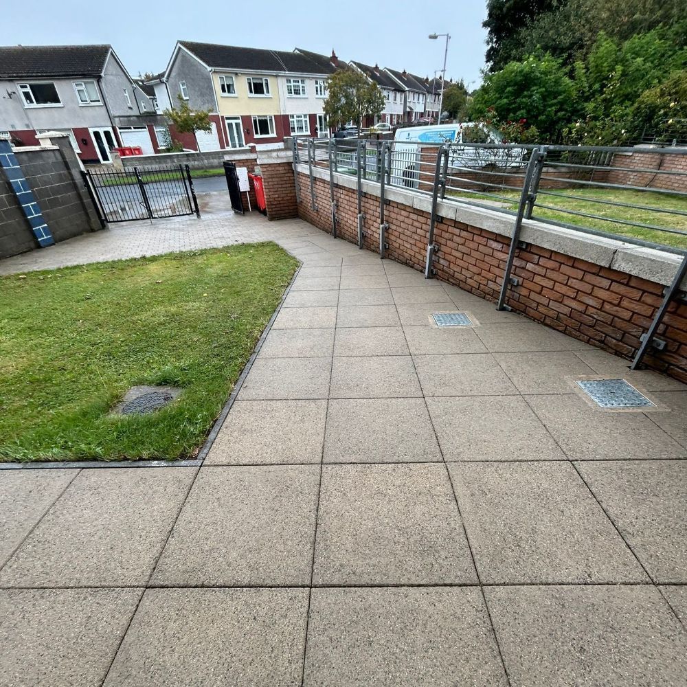 A patio with a brick wall and a fence surrounding it