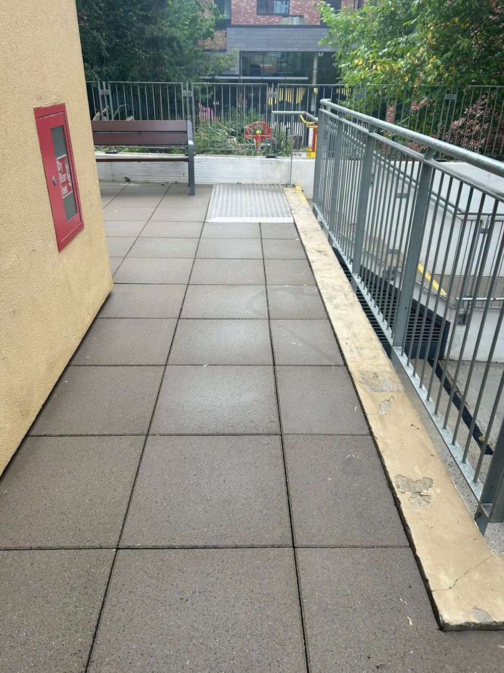 A walkway with a fire extinguisher on the side of it