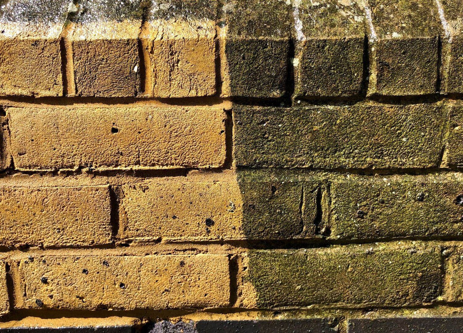 A close up of a brick wall before and after being cleaned.