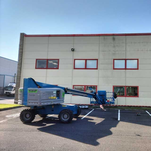A blue lift is parked in front of a building