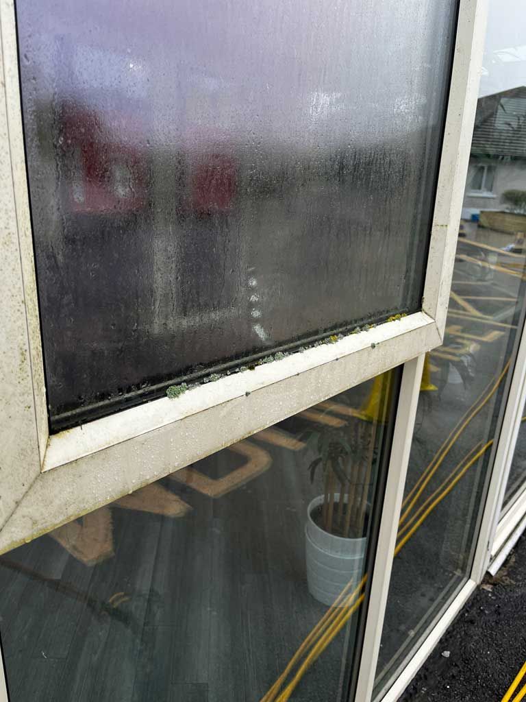 A close up of a window with a lot of condensation on it.