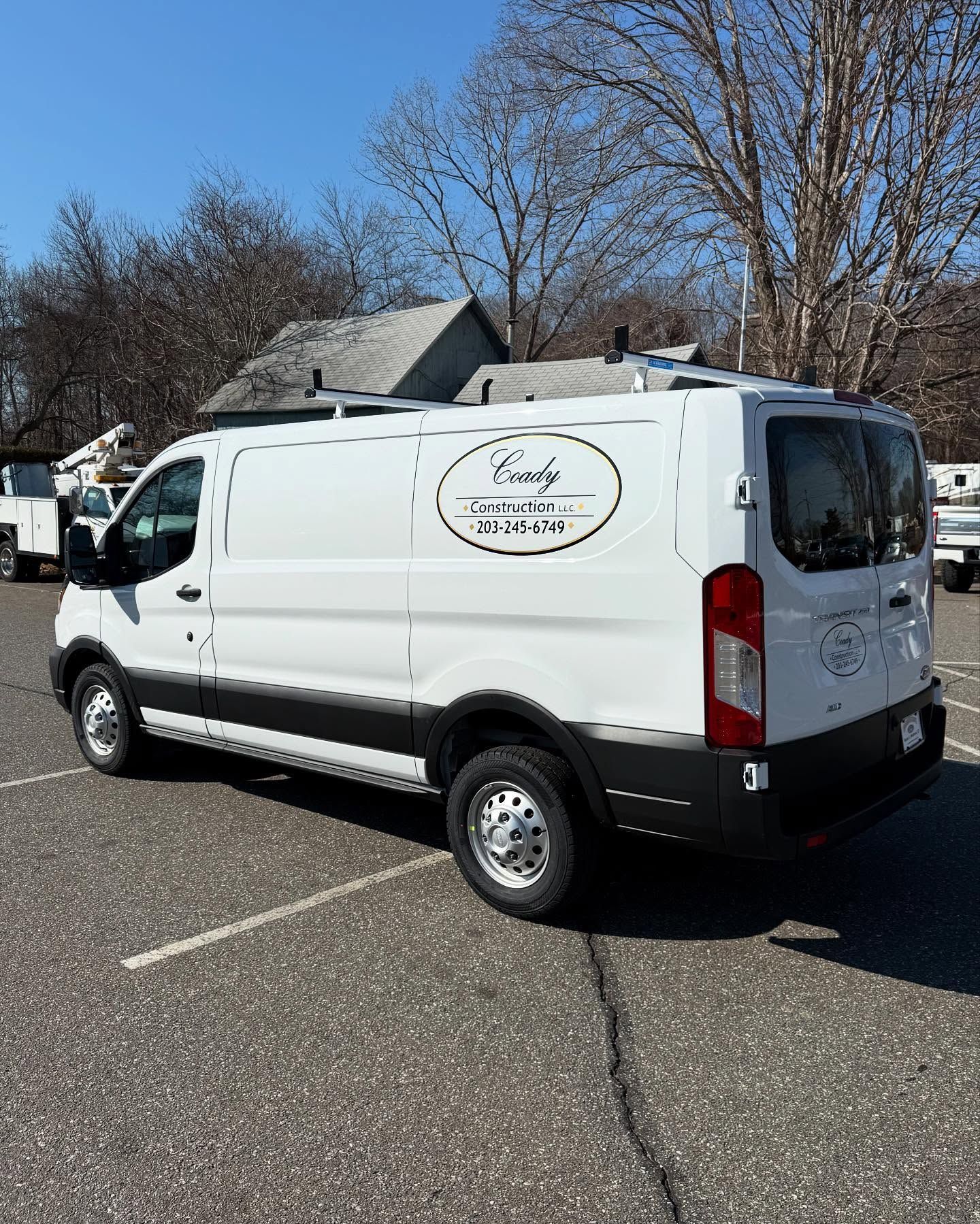 White commercial van parked in a lot with business logo on the side.