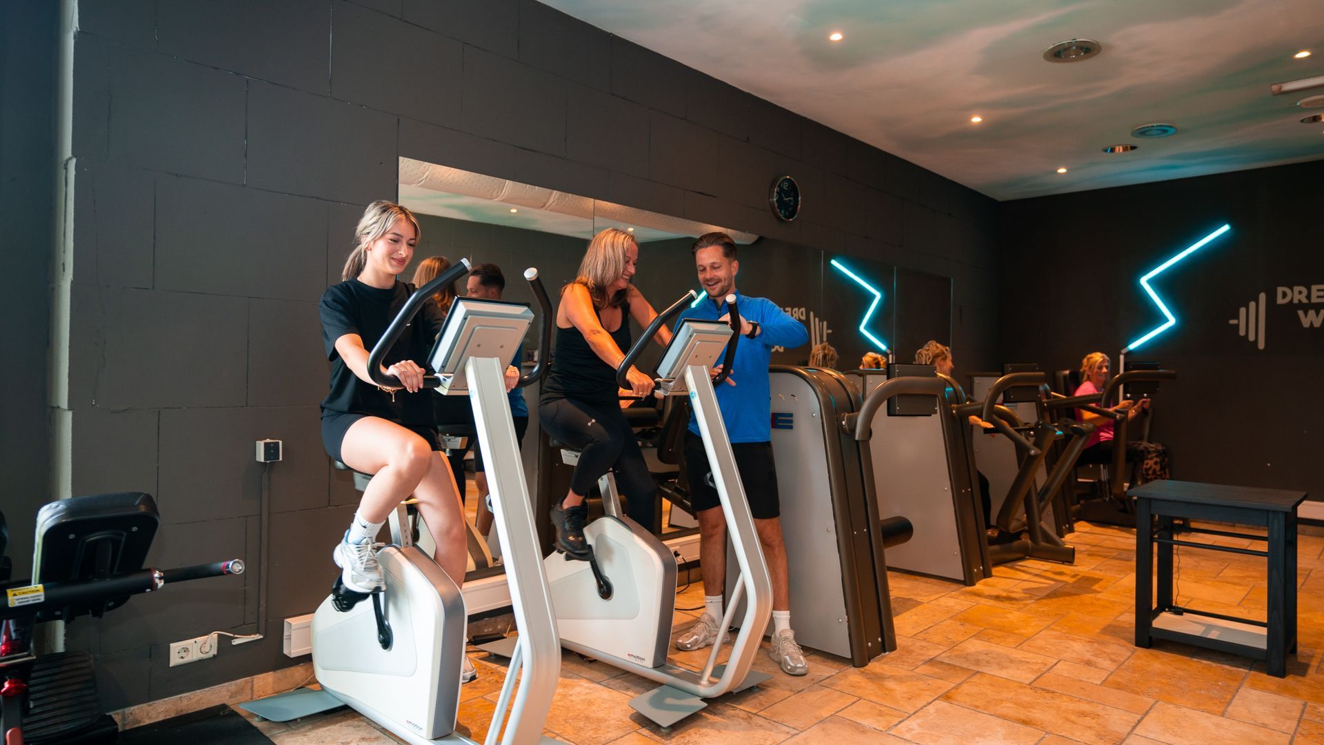 Een persoon tilt een halterstang op in een sportschool, met felgekleurde sportschoenen aan.