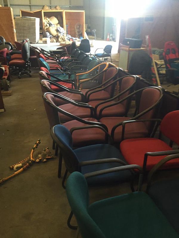 A Bunch Of Chairs Are Lined Up In A Warehouse — Dawson Moving & Storage NQ in Townsville, QLD