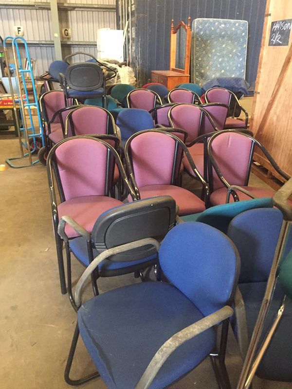 A Bunch Of Chairs Are Stacked On Top Of Each Other In A Warehouse — Dawson Moving & Storage NQ in Townsville, QLD