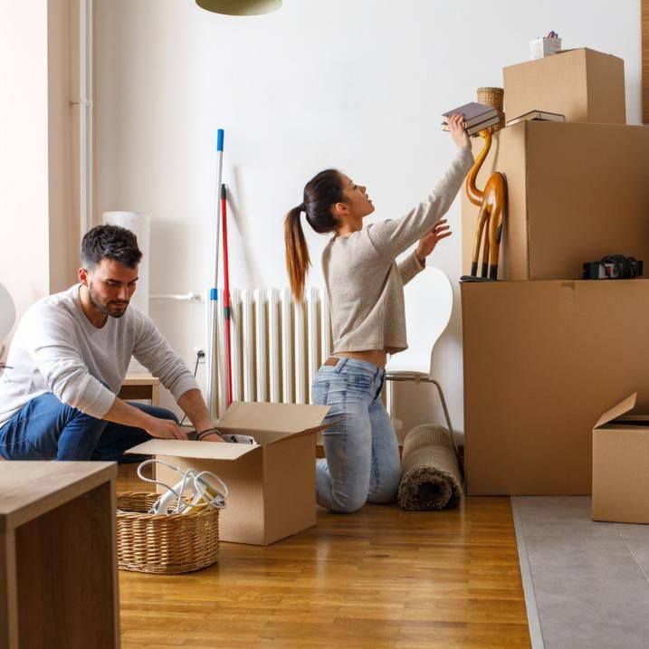 Two Individuals Unpacking Moving Boxes In Their Newly Acquired Home — Dawson Moving & Storage NQ in Melbourne, VIC