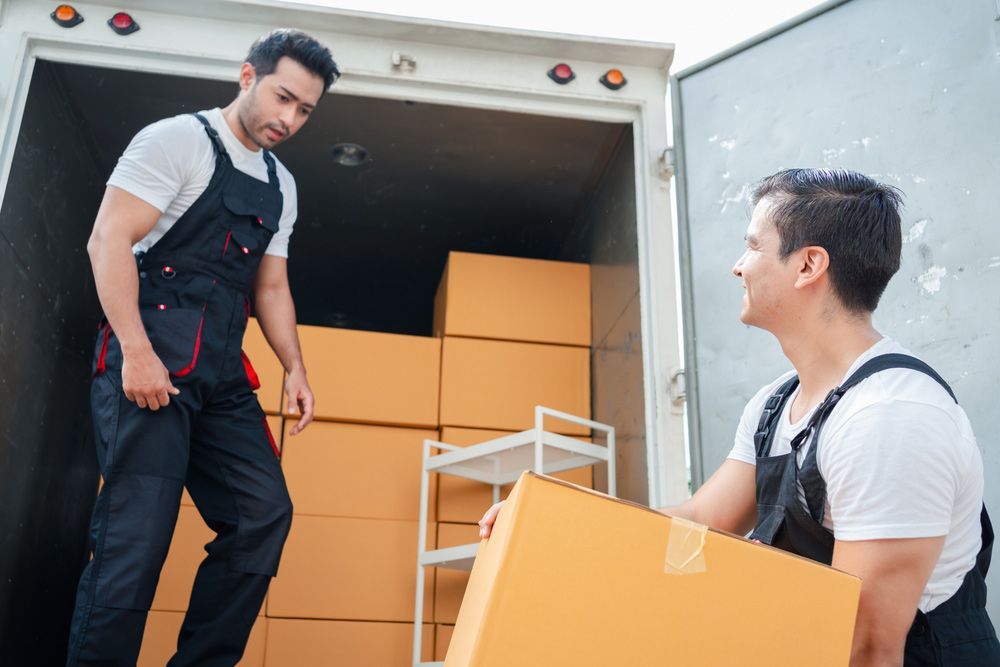 Two Men Are Loading Boxes Into A Truck — Dawson Moving & Storage NQ in Canberra, ACT
