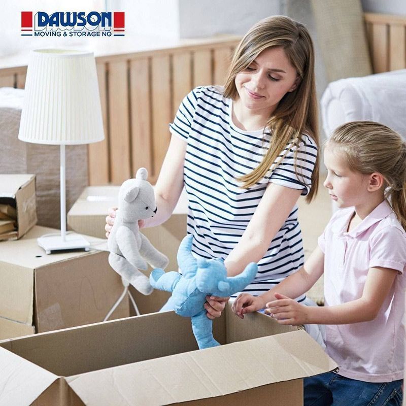 A Woman And A Little Girl Are Putting Stuffed Animals In A Cardboard Box — Dawson Moving & Storage NQ in Townsville, QLD