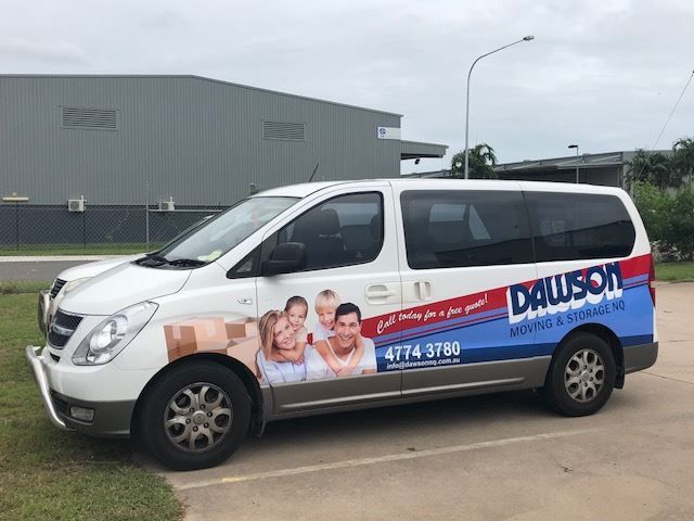 A White Van With A Picture Of A Family On The Side Is Parked In A Parking Lot — Dawson Moving & Storage NQ in Mount St John, QLD