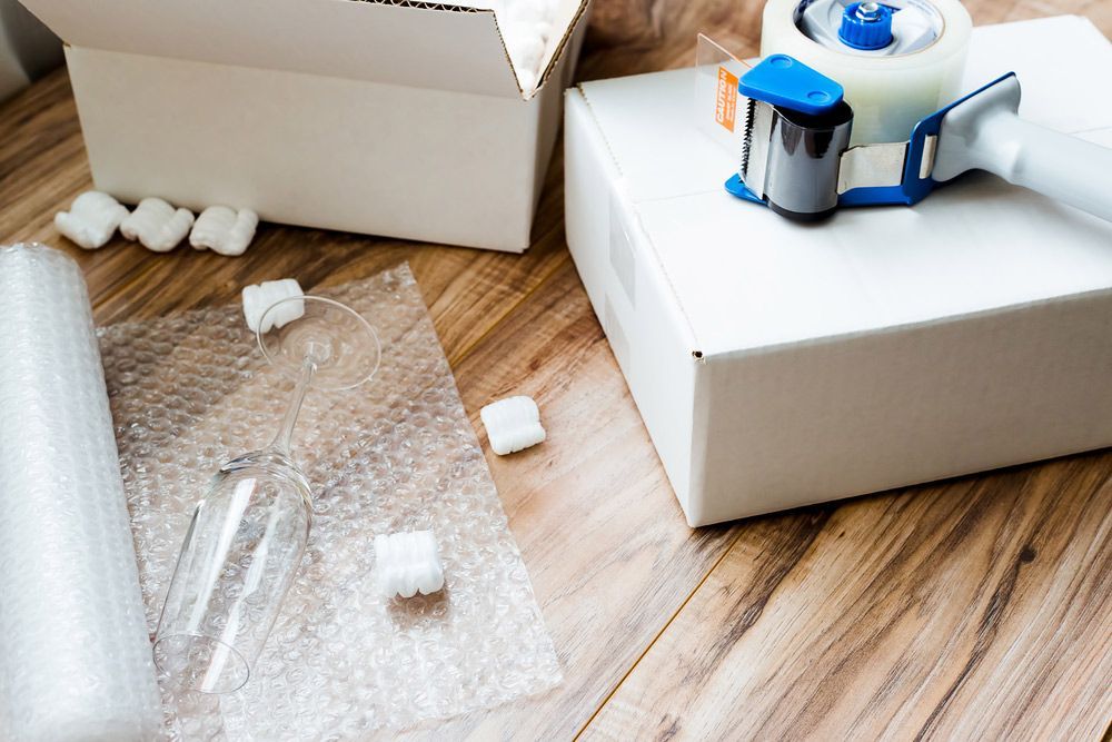 A Tape Dispenser Is Sitting On A Wooden Table Next To A Box — Dawson Moving & Storage NQ in Sunshine Coast, QLD