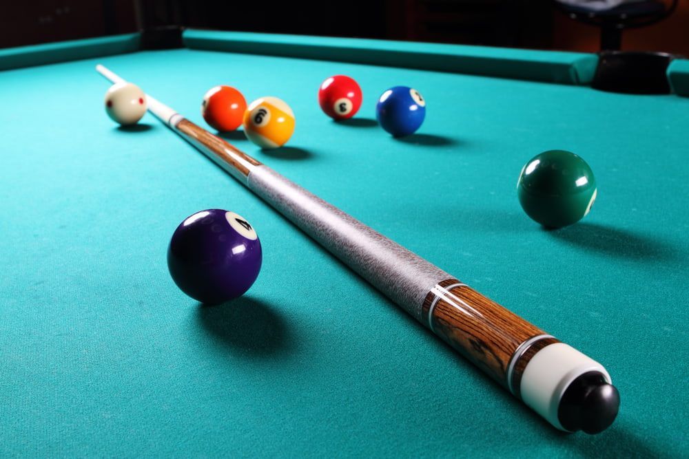 A Pool Table With Balls And A Cue On It — Dawson Moving & Storage NQ in Mount St John, QLD