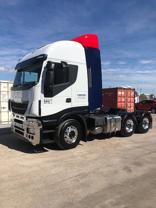 A Semi Truck With A Trailer Is Parked In A Parking Lot With Container Storage At The Background — Dawson Moving & Storage NQ in Townsville, QLD