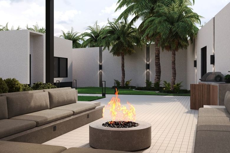 Modern patio with beige sofas, fire pit, and palm trees in a minimalist courtyard.