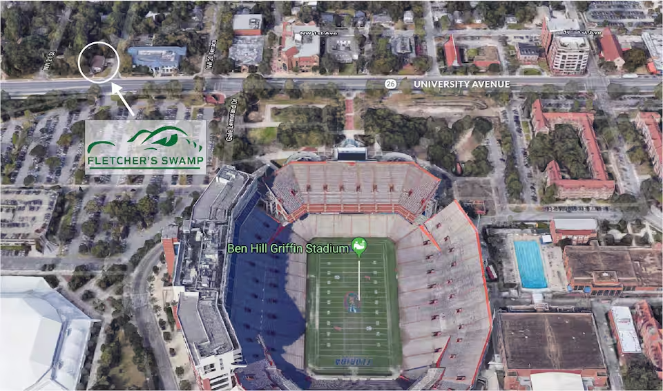 Aerial view of the University of Florida football stadium and surrounding area, including a street and nearby buildings.