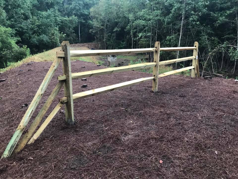 A wooden fence is sitting in the middle of a field.