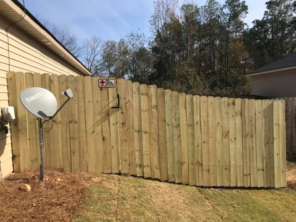 A wooden fence in Columbus Ga with a satellite dish attached to it