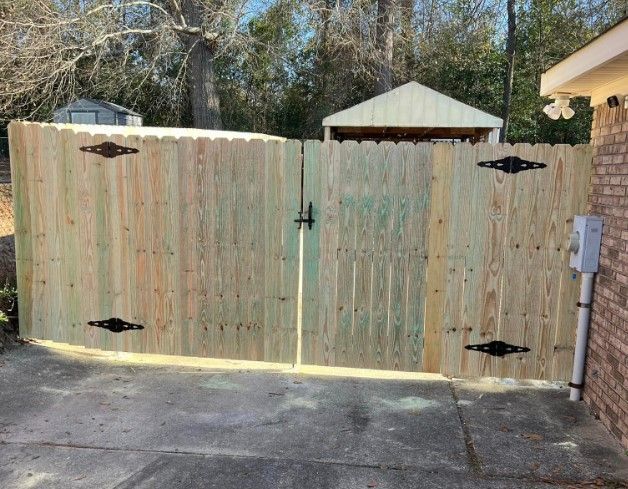 A wooden fence with a gate is in front of a house.