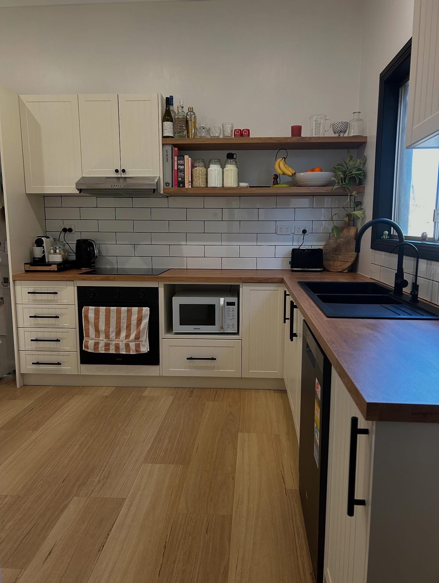 L-shaped kitchen with white cabinets, wood countertops, and stainless steel appliances. — Straight up Building Projects in Holt, ACT