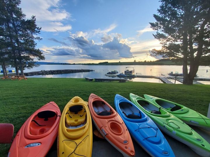 line of six colorful kayaks on lakefront