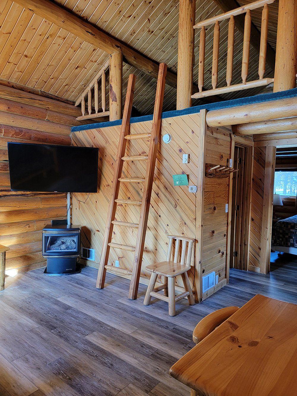 A TV beside a stairs to the attic