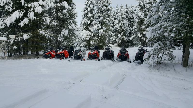 Snowbike riders lined up with their snowbikes