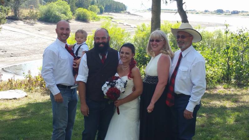 Happy newly wedded couple with their family