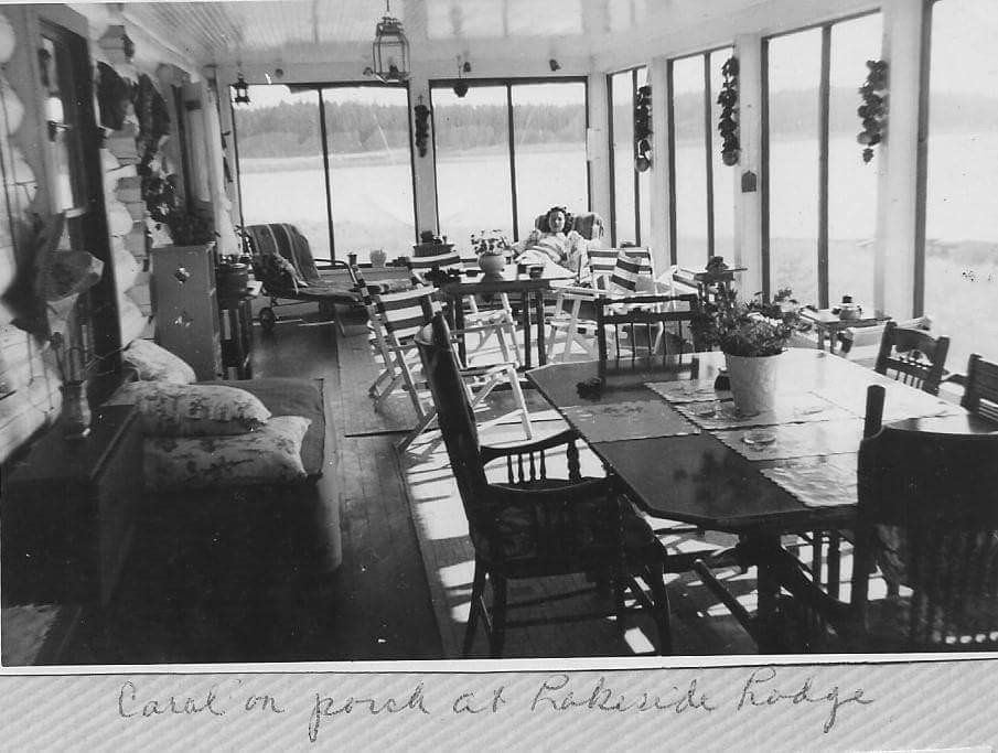 black and white picture of woman sitting in corner of empty restaurant