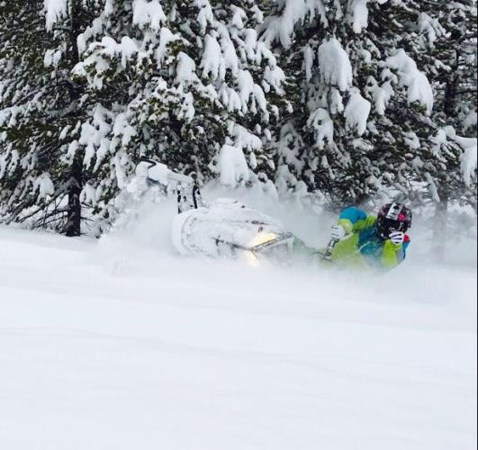 A rider doing stunt on a snowmobile