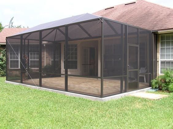 Screened-in backyard porch attached to a house, with dark mesh panels and a wooden floor.