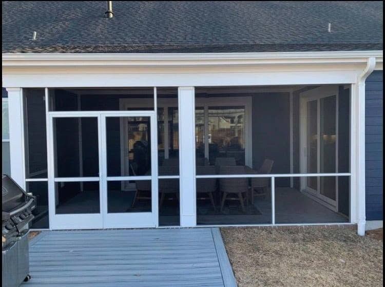 Screened porch with white trim, sliding glass doors, and a small deck in front