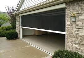 Residential garage with a partially open black roll-up door on a rainy driveway