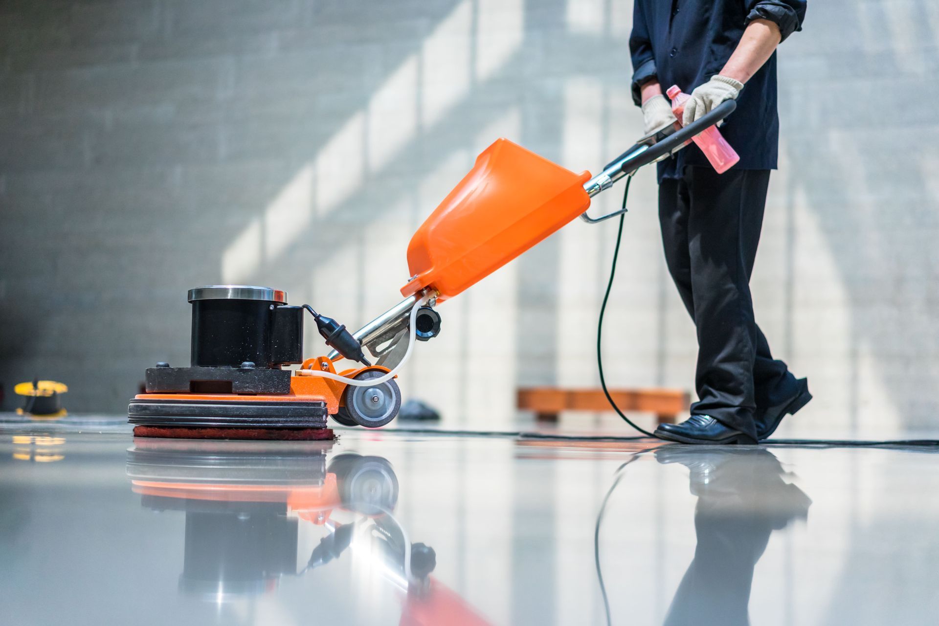A man is cleaning the floor with a machine.