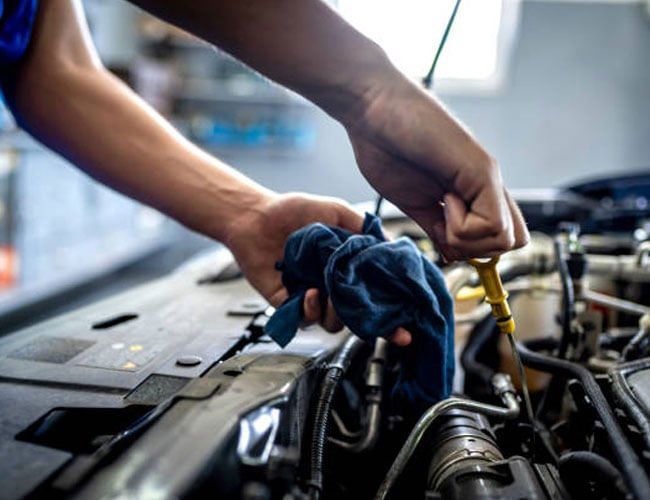 mechanic checking engine fluid levels mechanic checking engine fluid levels