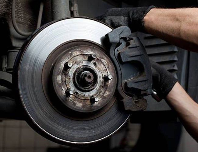 mechanic repairing an automobile brake mechanic repairing an automobile brake