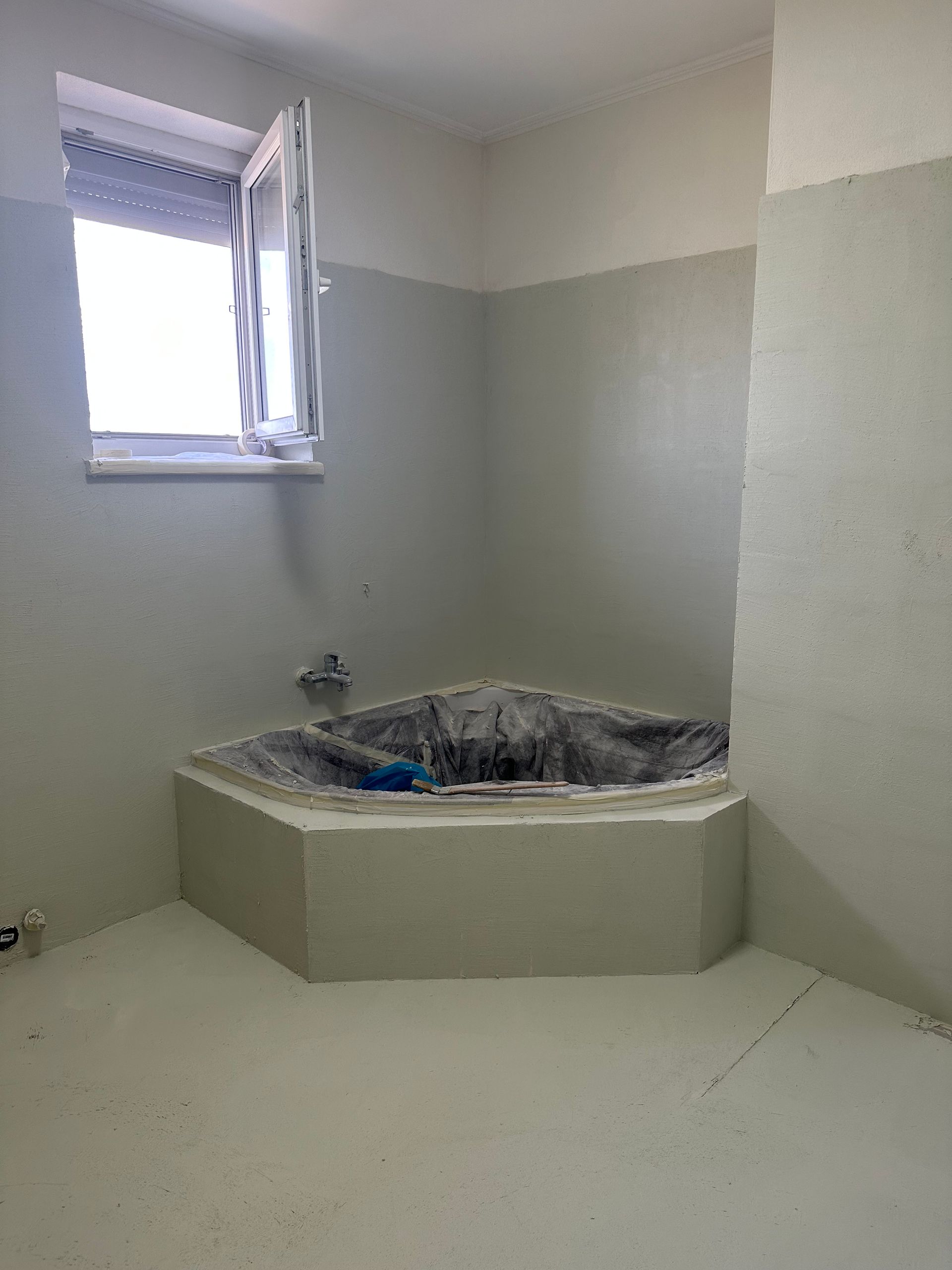 Ein Badezimmer mit Whirlpoolwanne und Fenster.