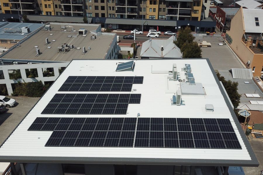 An aerial view of a building with solar panels on the roof.