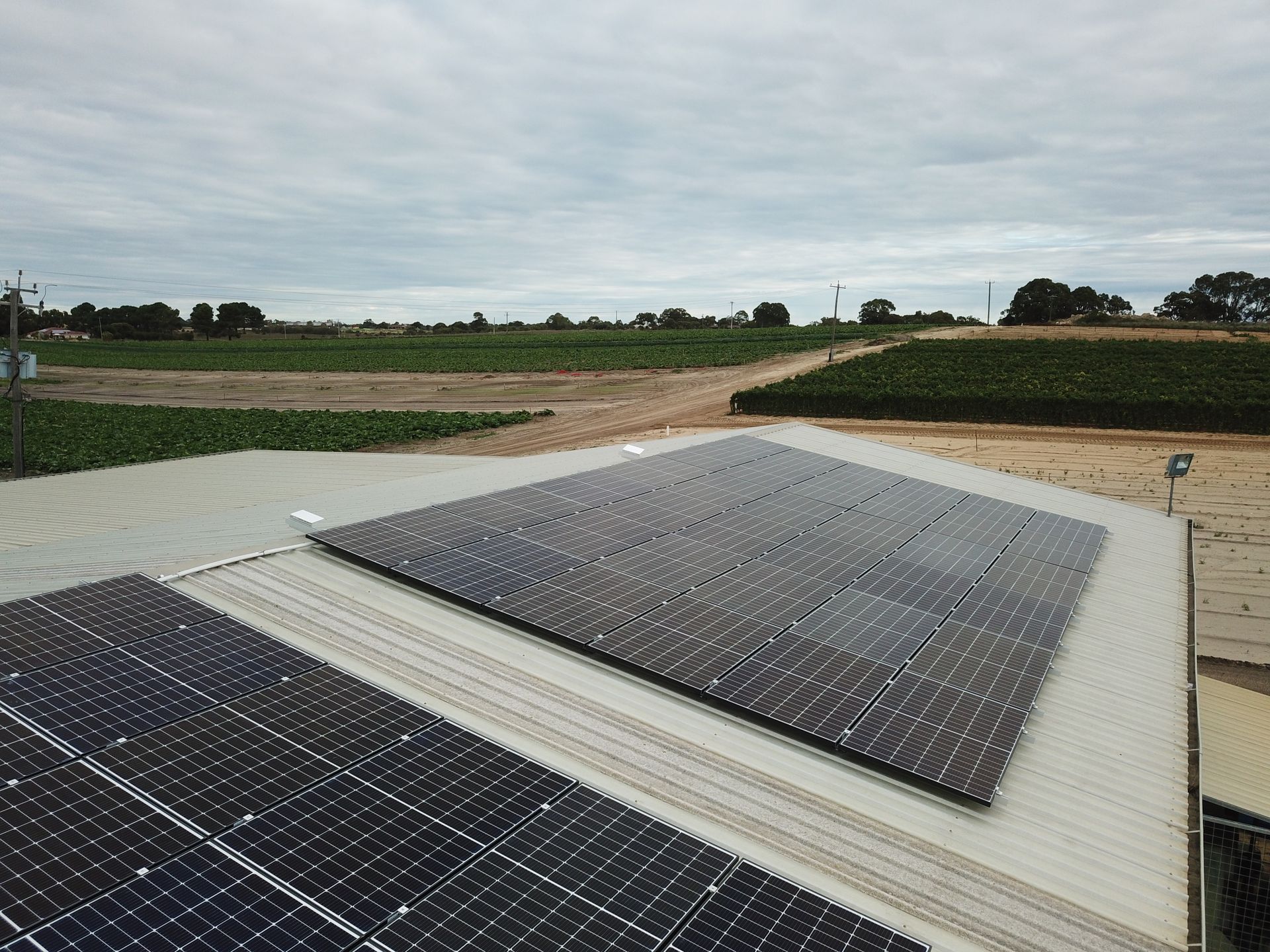 There are many solar panels on the roof of a building.