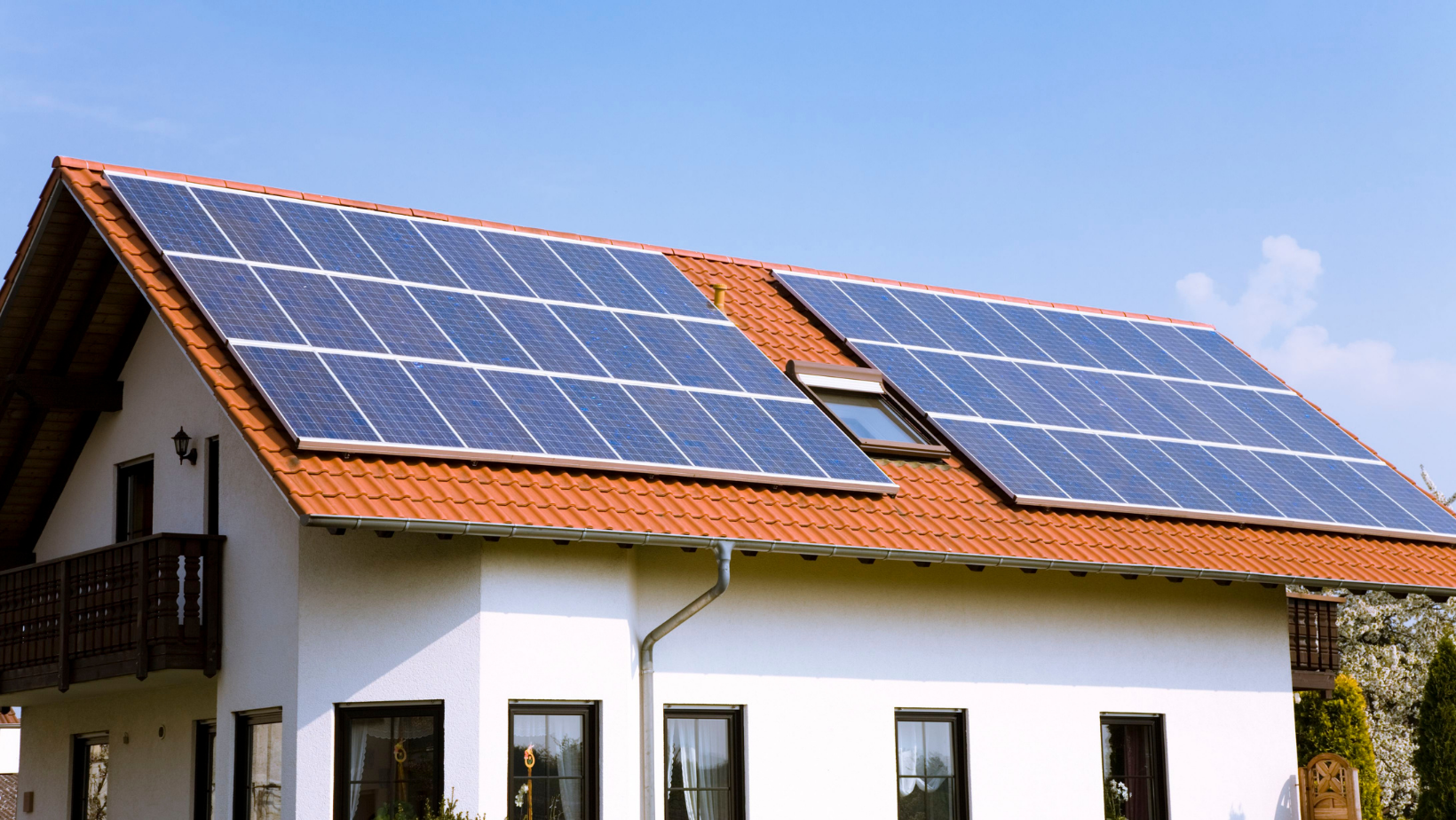 A white house with solar panels on the roof